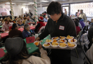 Horace Del Rio, 16, of De La Salle high school, serves bowls of fresh fruit at the Monument Crisis Center in Concord, Calif. where a Share the Spirit grant helped host a meal and food distribution for seniors on Friday afternoon Dec. 4, 2009. The Volunteer Center of the East Bay, which administered the Share the Spirit campaign, has announced it will be shutting down. (Karl Mondon/Staff Archives)