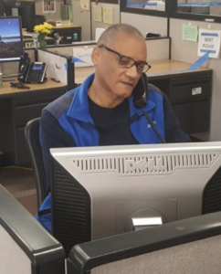 One of our friendly and helpful call specialists is seated at desk viewing computer screen and answering phone.