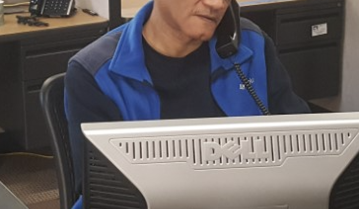 One of our friendly and helpful call specialists is seated at desk viewing computer screen and answering phone.